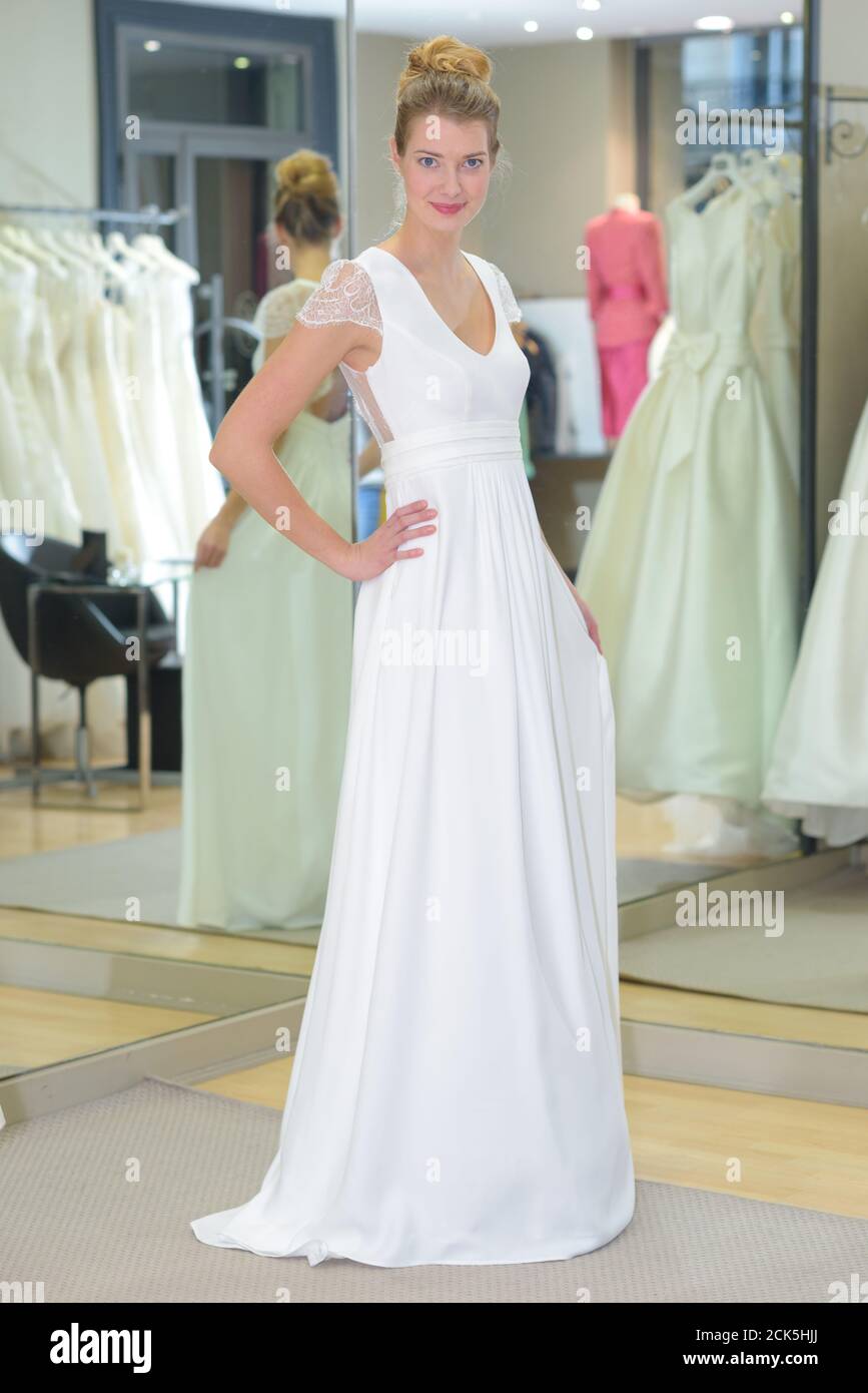 Frauen, die versuchen, auf Hochzeit Kleid in einem Geschäft Stockfoto
