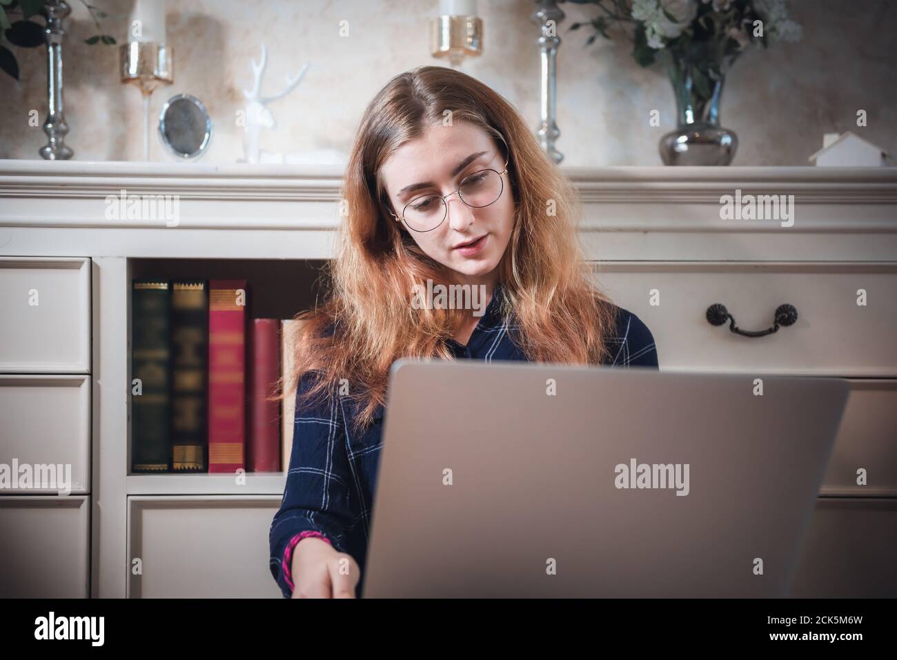 Junge Frau arbeitet am Computer Laptop zu Hause, Geschäftsfrau in beschäftigt Arbeit, während Online-Konferenz Virtuelle Konversation auf Laptop von zu Hause. Technolog Stockfoto