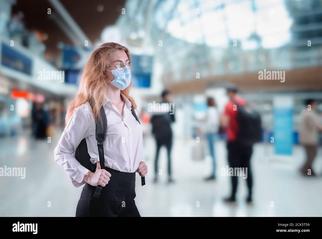 Tourist Frau mit Schutz Gesichtsmaske am Flughafen-Terminal in Coronavirus Covid-19 Pandemie, defensive Maßnahme für Reisebeschränkungen von Touristen Stockfoto