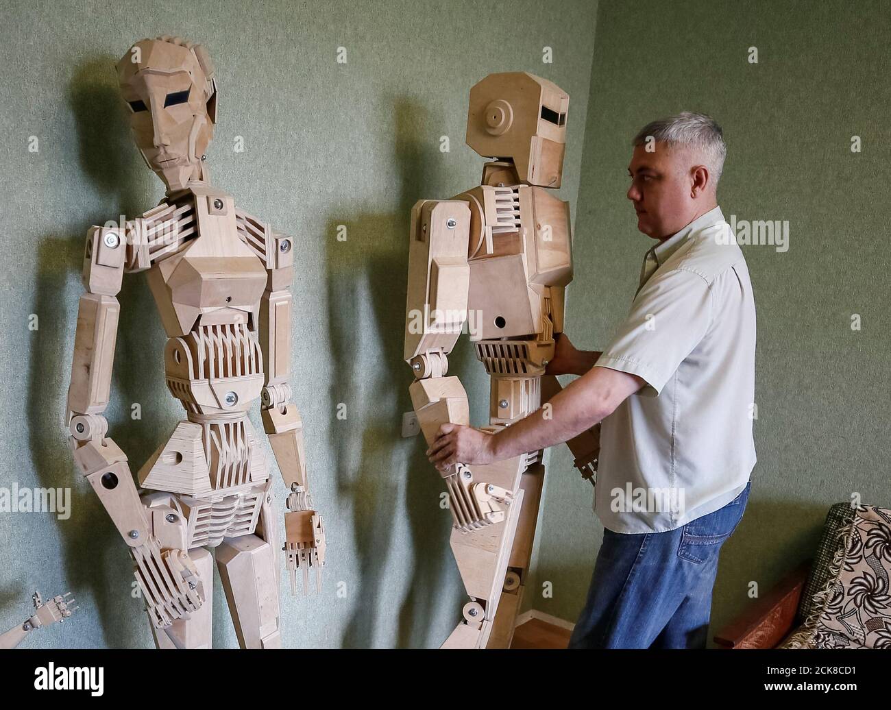 Dmitry Balandin ist mit seinen Holzmodellen Centurio und Amazon (L) in  seiner Wohnung in Zaporizhzhya, Ukraine, Ukraine, 5. Juli 2017 abgebildet.  Balandin, der als Kranführer arbeitet, brauchte achtzehn Monate, um Modelle  aus