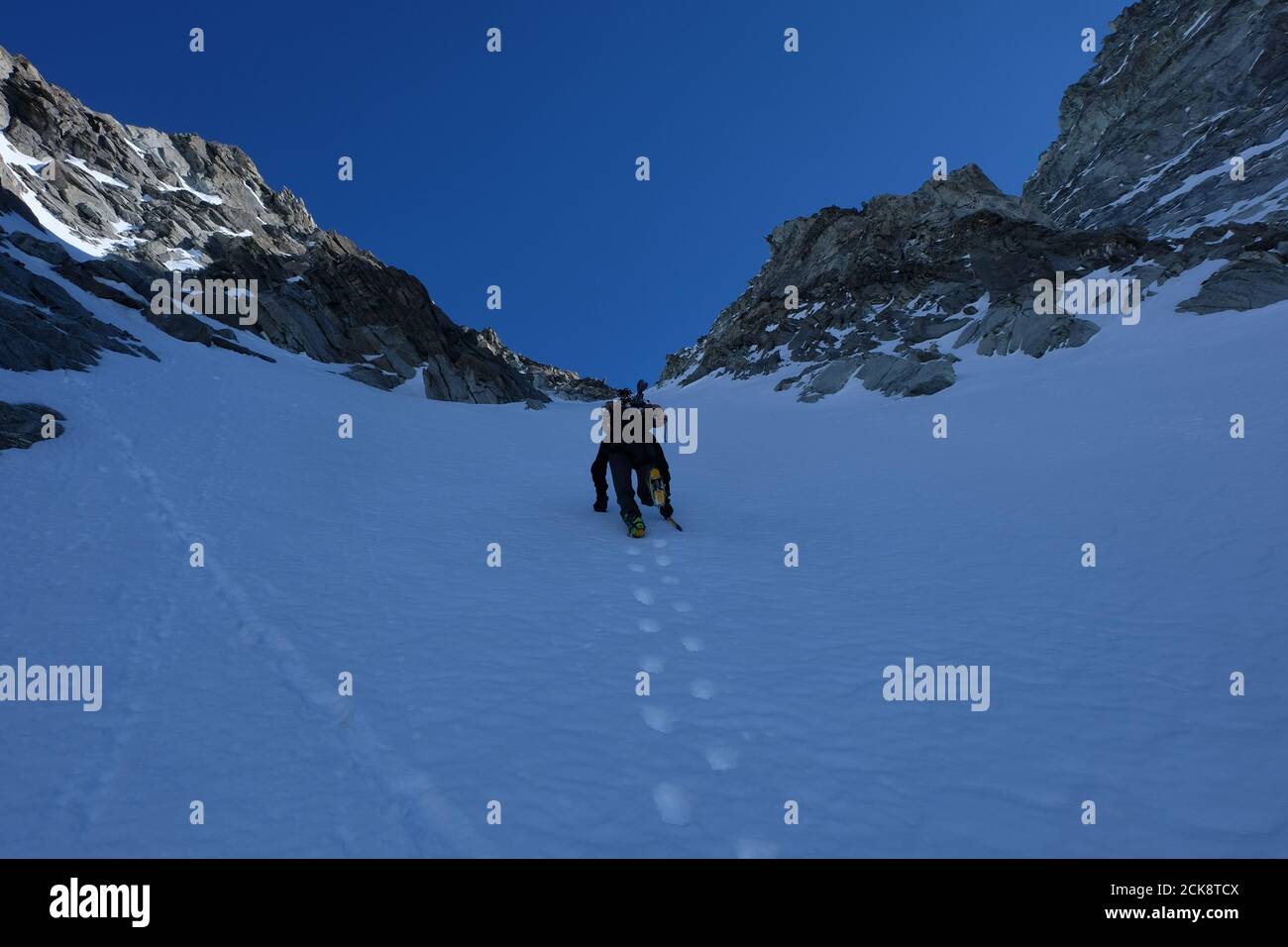 Winterbesteigung mit Steigeisen und Eispickel, Ski auf dem Rücken, Couloir Anzévui, Aiguille de la TSA, Wallis, Schweiz Stockfoto