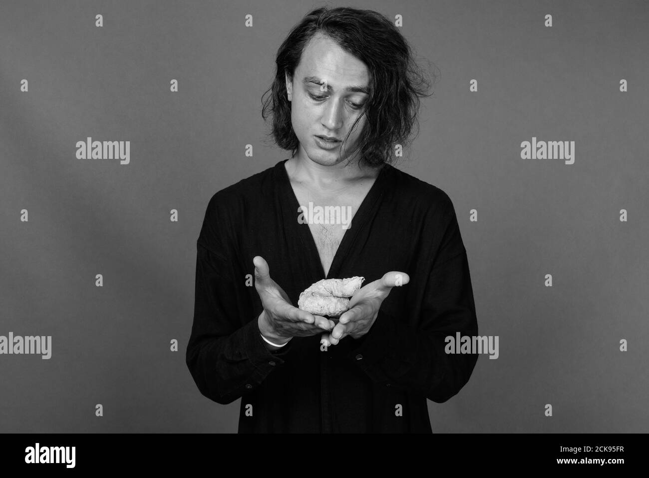 Porträt der jungen gutaussehenden Mann gegen grauer Hintergrund Stockfoto