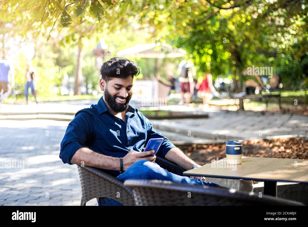 Junger erfolgreicher Geschäftsmann, der im Café im Freien arbeitet. Stockfoto