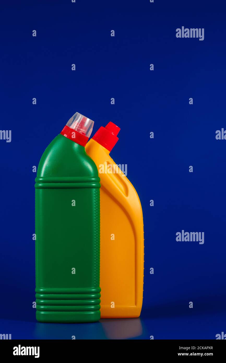 Flaschen mit verschiedenen Farben und Waschmittel auf blauem Hintergrund. Stockfoto