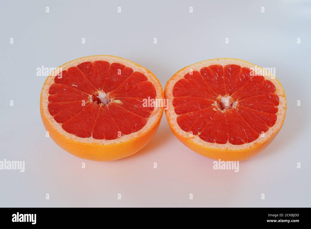 Früchte sind Zitrusfrüchte. Rote Grapefruit in zwei Hälften geschnitten. Stockfoto