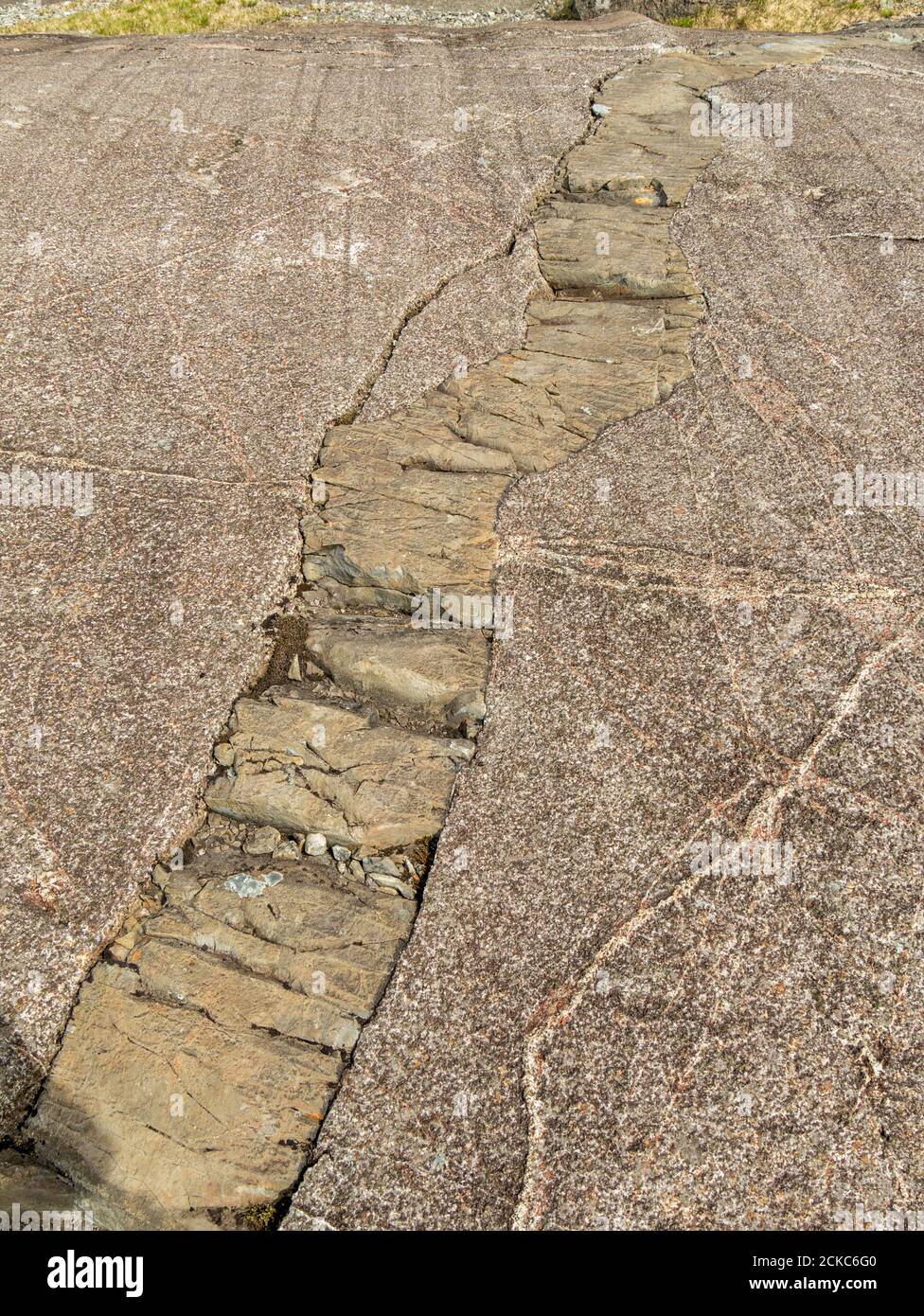 Glazial polierte Oberfläche aus geschichtetem Mineral Gabbro mit einer unheilvollen Intrusion an der Lippe von Coire Lagan in den Black Cuillin Mountains, Skye, Schottland. Stockfoto