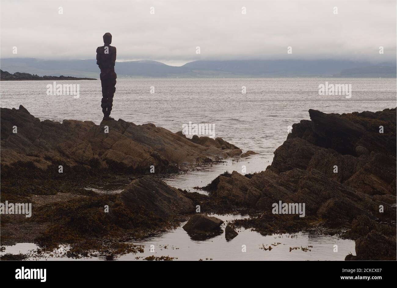 Anthony Gromleys SKULPTURENGRIFF an der Saddell Bay steht auf Felsen Blick auf Kilbrannan Sound mit der Kintyre Halbinsel in Der Hintergrund Stockfoto