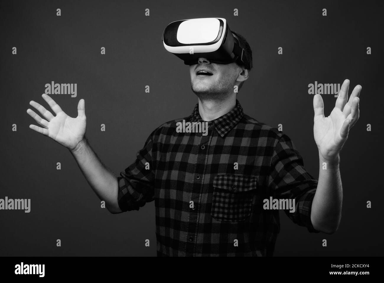 Porträt eines Hipster-Mannes mit VR-Brille vor grauem Hintergrund Stockfoto