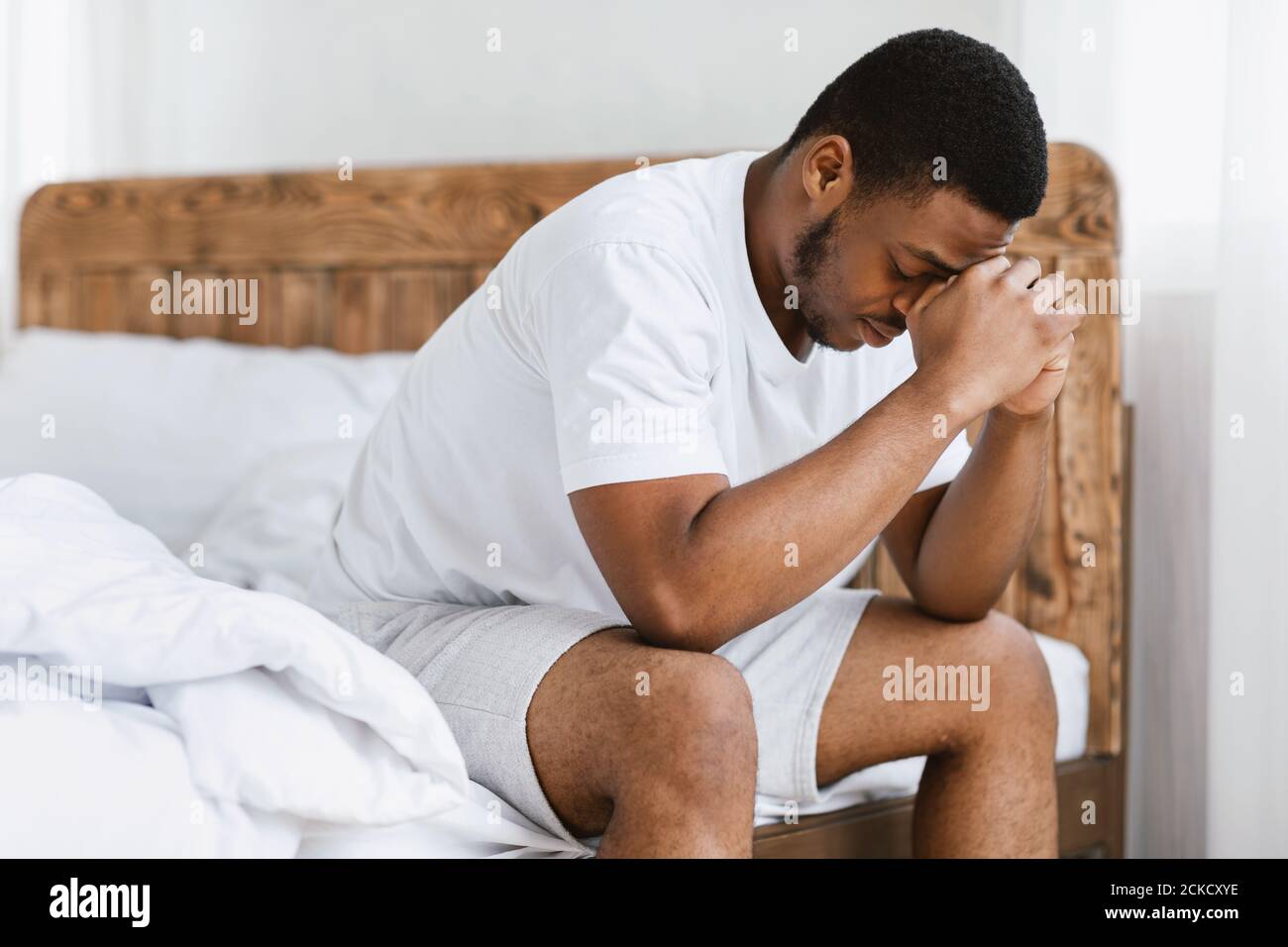 Depressive African Guy Mit Schlaflosigkeit Sitzen Auf Bett Zu Hause Stockfoto