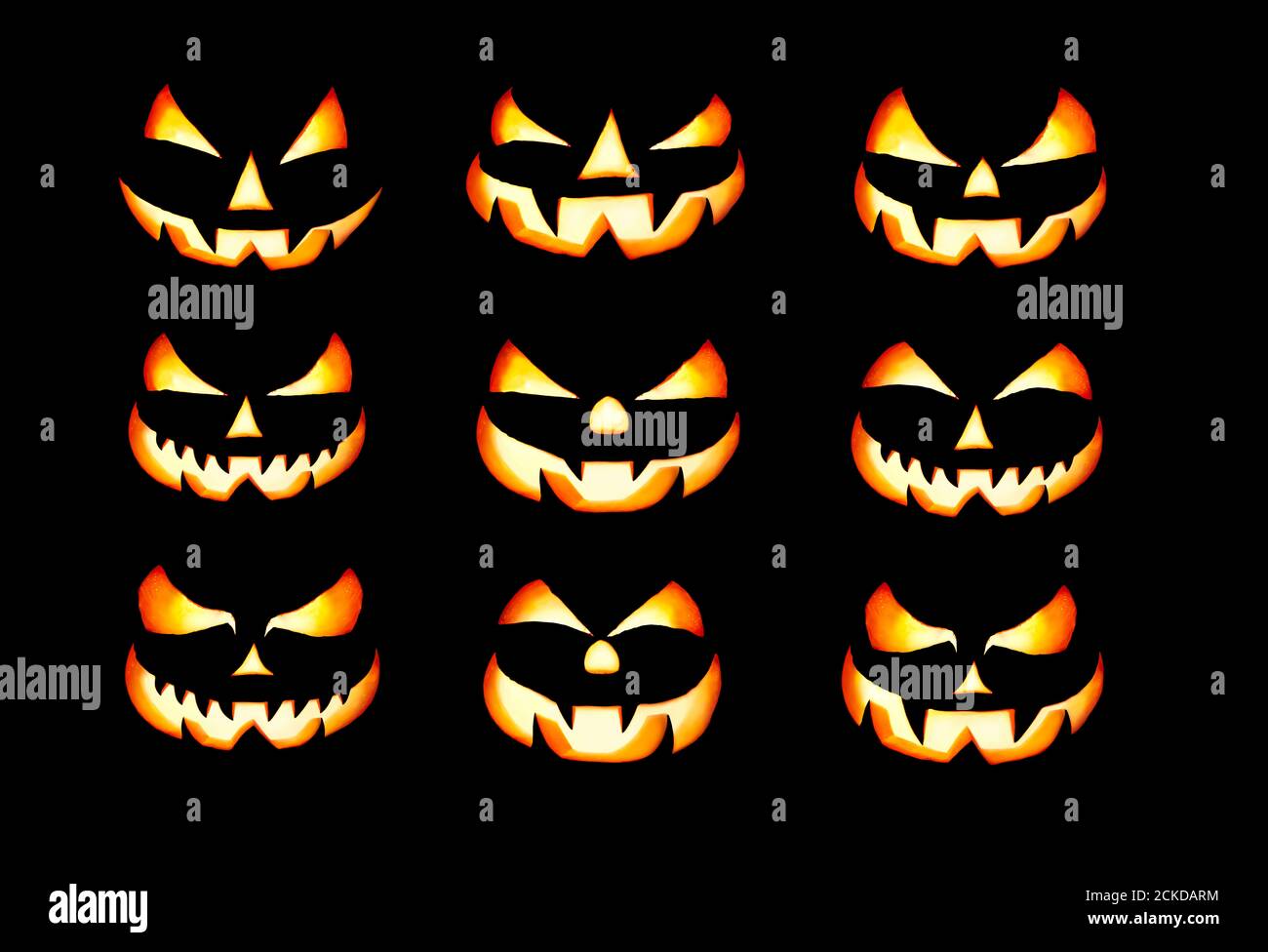 Neun angezündete böse halloween Laterne Gesichter, Jack O Laterne, mit leuchtenden Augen isoliert vor einem schwarzen Hintergrund bereit, auf nächtlichen Kürbis verwendet werden Stockfoto