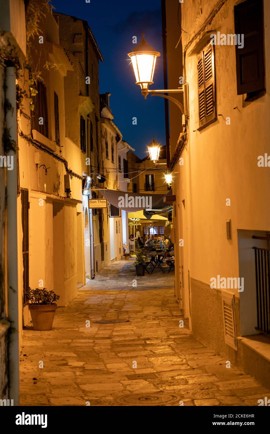 Restaurant in alten beleuchteten engen Straße in Mahon bei Nacht - Menorca, Spanien Stockfoto