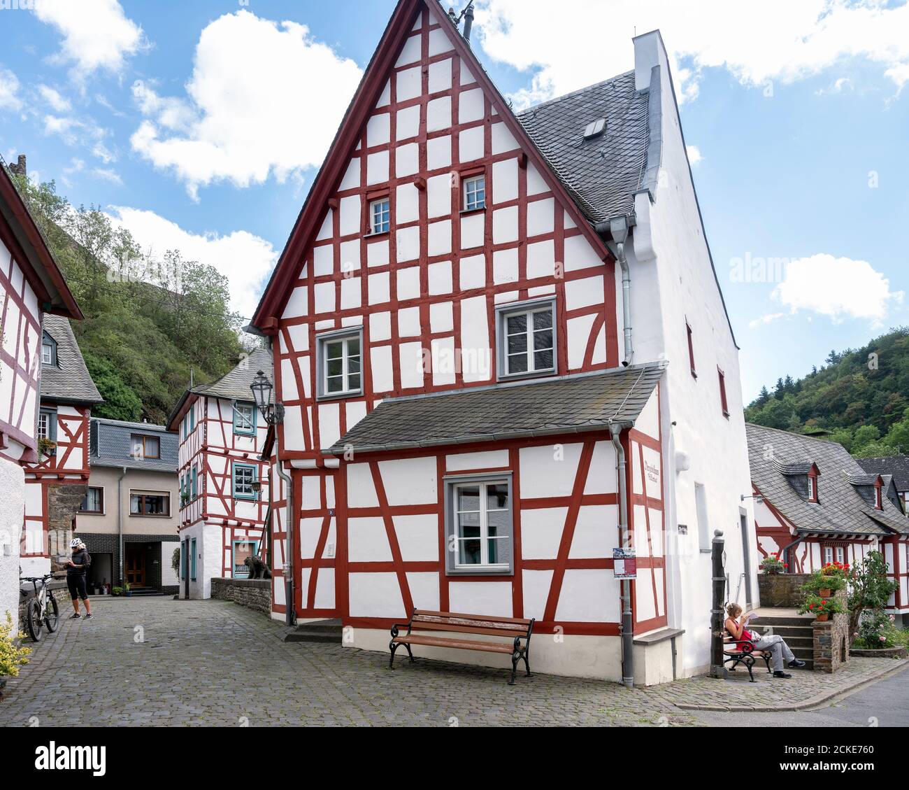 Die Menschen ruhen in der Nähe von Fachwerkhäusern und Burgruine Schönes Dorf Monreal in der deutschen eifel Stockfoto