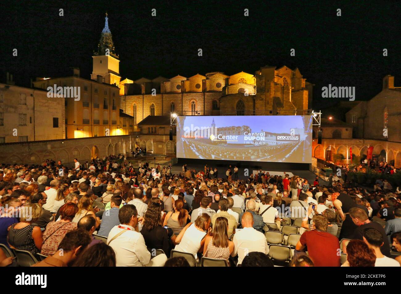 Die Outdoor-Nachtaufnahme mit einem vollgepackten Publikum und riesigen Bildschirm bei Visa Pour L'image statt jährlich in Perpignan, Südfrankreich Stockfoto