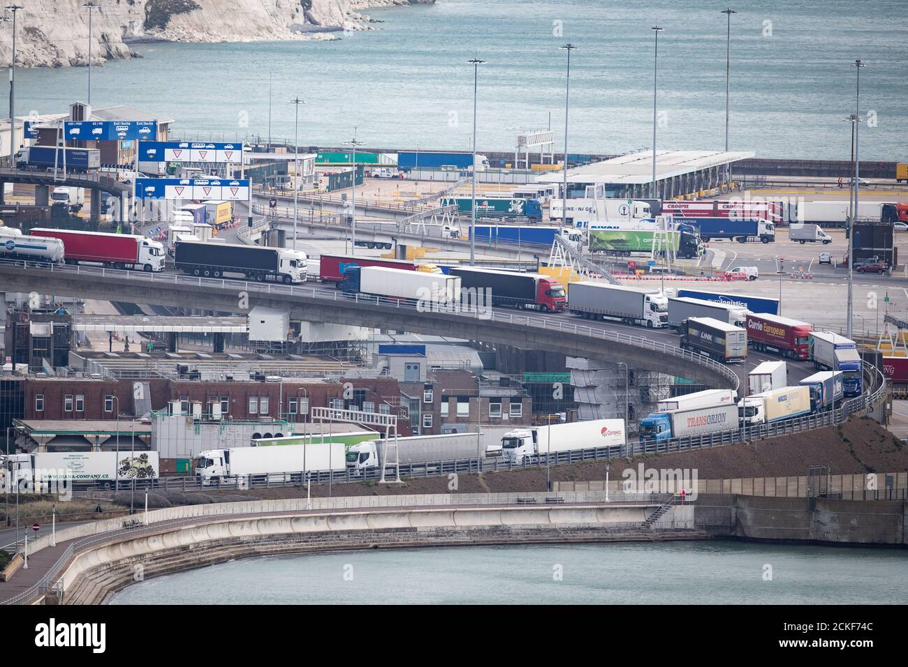 Lastwagen stehen Schlange, um den Hafen in Dover, Kent, zu betreten, wo eine andauende Polizeioperation für lange Verspätungen bei Fahrzeugen gesorgt hat. Stockfoto