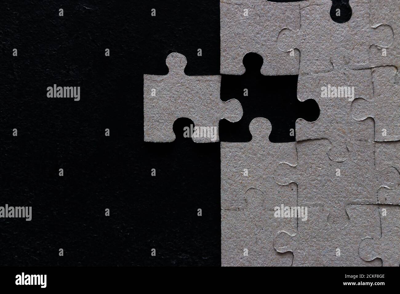 Fehlende Stück in einem Puzzle auf einem schwarzen Hintergrund mit Leerzeichen für Text Stockfoto