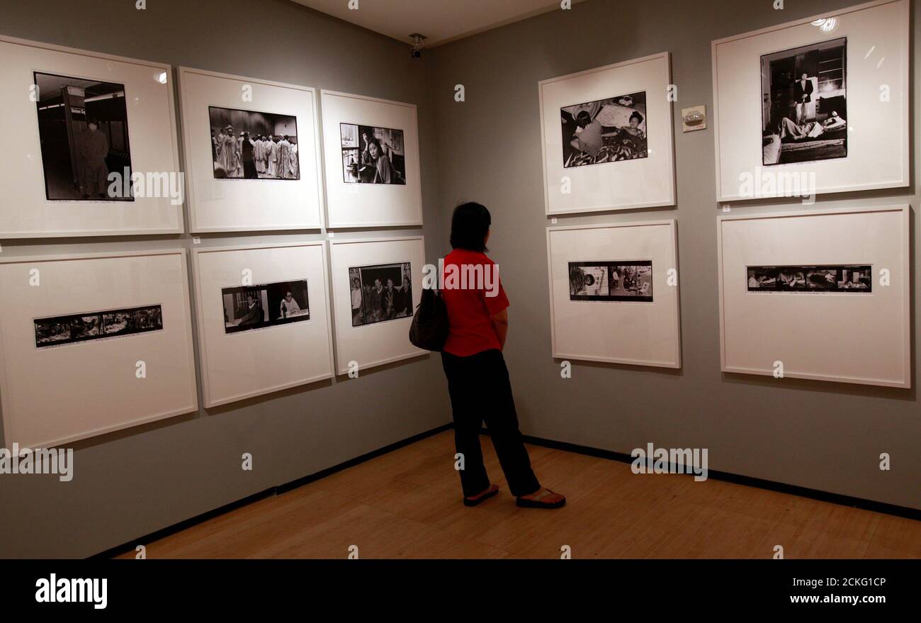 Eine Frau betrachtet Fotos während einer Vorschau auf eine Ausstellung des chinesischen Künstlers Ai Weiwei in der Asia Society in New York, 29. Juni 2011. Eine Fotoausstellung, die Einblicke in die Zeit des chinesischen Künstlers und Aktivisten Ai Weiwei in den 1980er und frühen 1990er Jahren in New York bietet, wurde am Mittwoch eröffnet und markiert damit die erste große Museumsausstellung seines Werks seit seiner Freilassung aus der Haft. REUTERS/Brendan McDermid (VEREINIGTE STAATEN - Tags: UNTERHALTUNG GESELLSCHAFT) Stockfoto