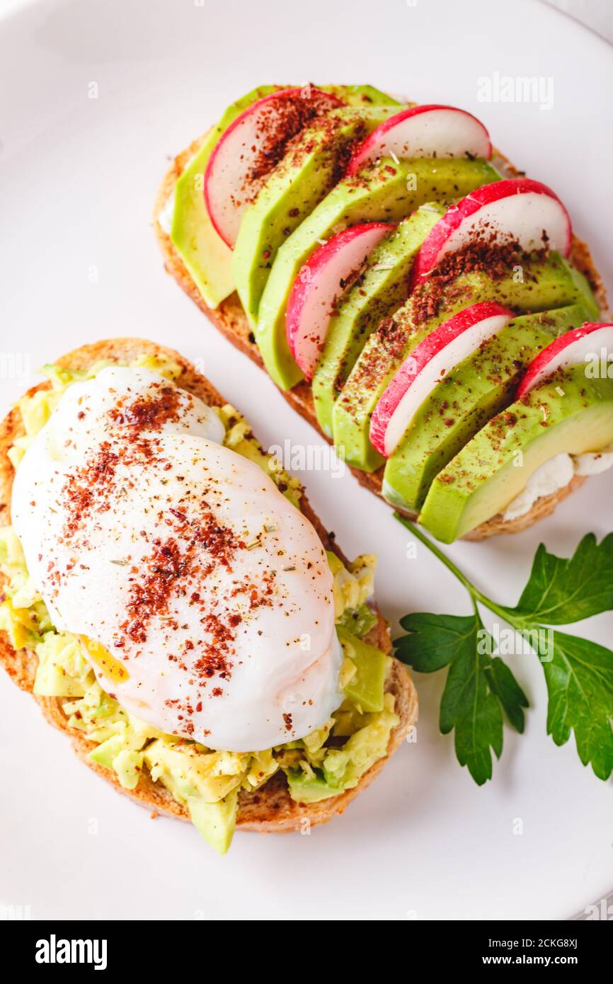 Toast mit Avocado und pochiertem Ei und Toast mit Avocado und Rettich. Gesundes Lebensmittelkonzept. Stockfoto