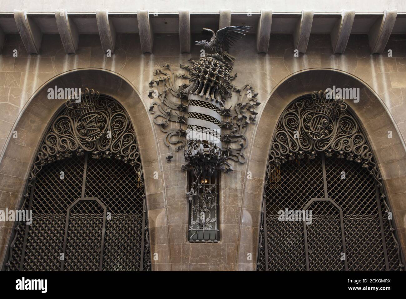 Das schmiedeeiserne Wappen Kataloniens ist am Haupttor des Palau Güell abgebildet, der vom katalanischen modernistischen Architekten Antoni Gaudí in Barcelona, Katalonien, Spanien entworfen wurde. Das Herrenhaus im Auftrag des katalanischen Industriemagnaten Eusebi Güell wurde zwischen 1886 und 1890 erbaut. Die geschmiedeten Eisenmonogramme E und G werden an den Besitzer des Herrenhauses verwiesen. Stockfoto