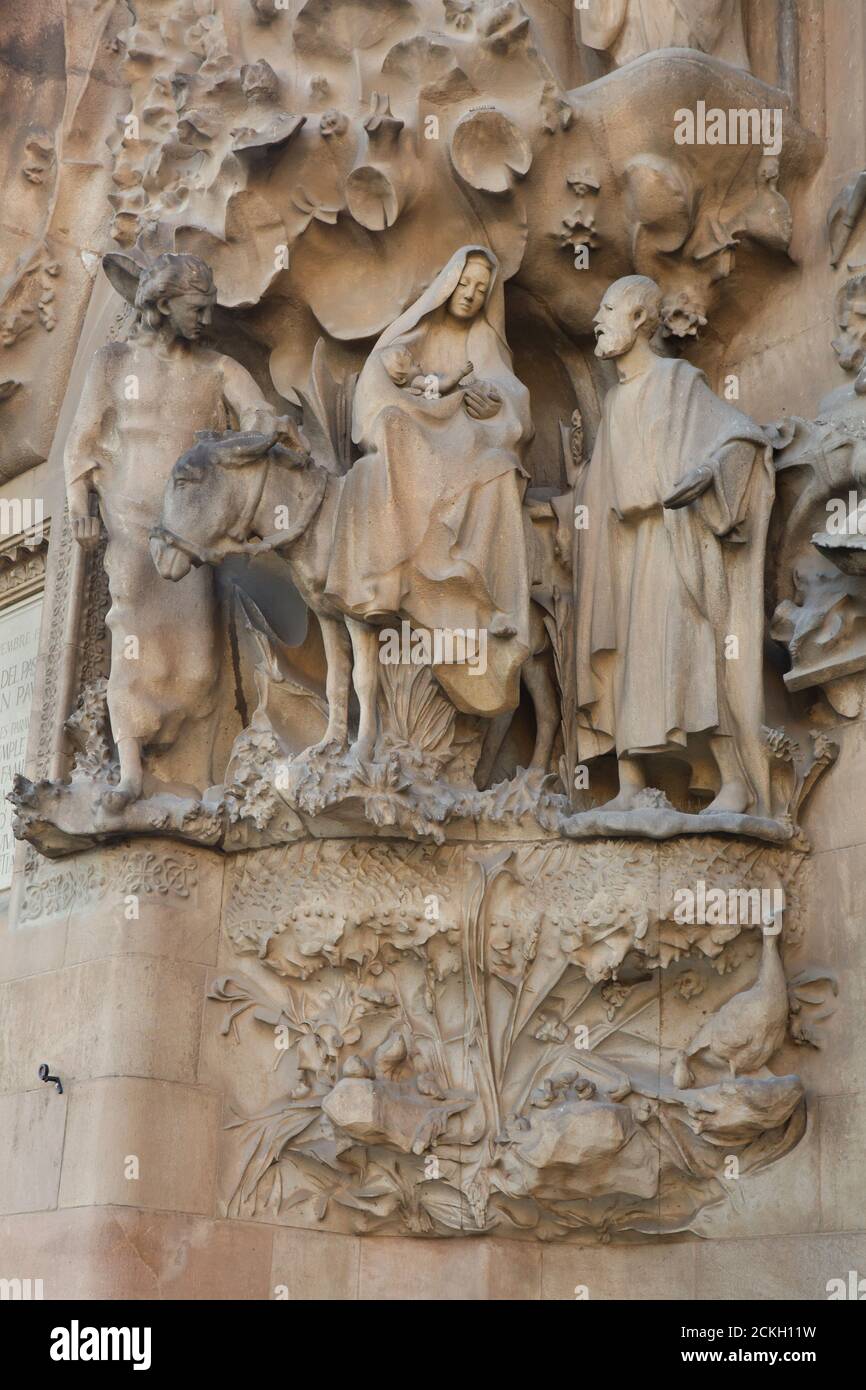 Flug nach Ägypten auf der Krippenfassade der Sagrada Família (Basílica de la Sagrada Família) dargestellt, entworfen vom katalanischen modernistischen Architekten Antoni Gaudí in Barcelona, Katalonien, Spanien. Die Weihnachtsfassade wurde von Antoni Gaudí selbst entworfen und zwischen 1894 und 1930 gebaut. Die Statuen wurden vom katalanischen modernistischen Bildhauer Llorenç Matamala i Piñol mit Unterstützung von Carles Mani i i Roig geschnitzt. Stockfoto