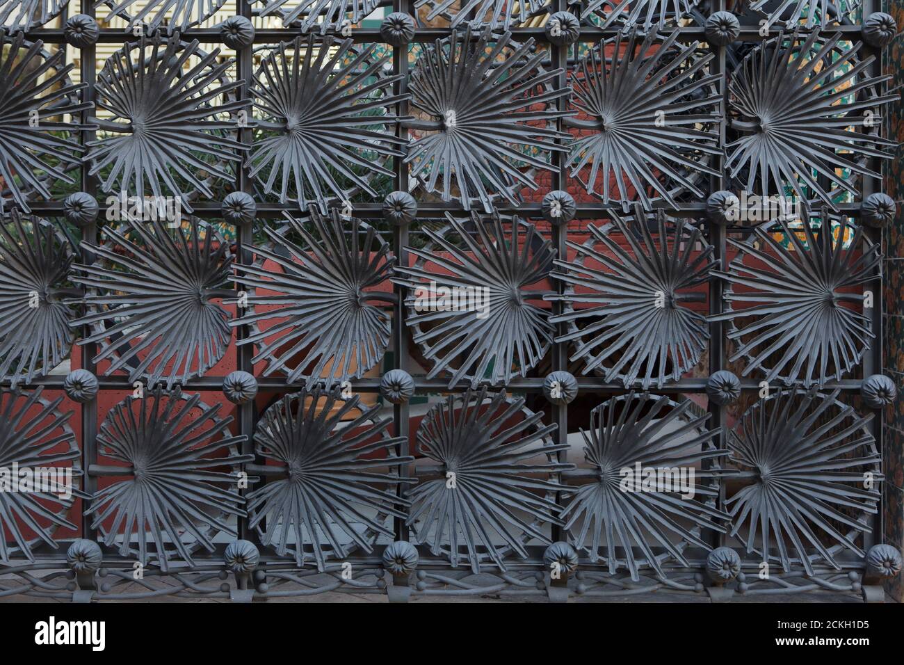 Gusseiserner Zaun der Casa Vicens, entworfen vom katalanischen modernistischen Architekten Antoni Gaudí in Barcelona, Katalonien, Spanien. Das Herrenhaus, das vom katalanischen Industriemagnaten Manuel Vicens als Sommerresidenz seiner Familie in Auftrag gegeben wurde, wurde zwischen 1883 und 1885 erbaut. Blätter der mediterranen Zwergpalme (Chamaerops humilis), auch als europäische Fächerpalme bekannt, sind im Zaun abgebildet. Stockfoto