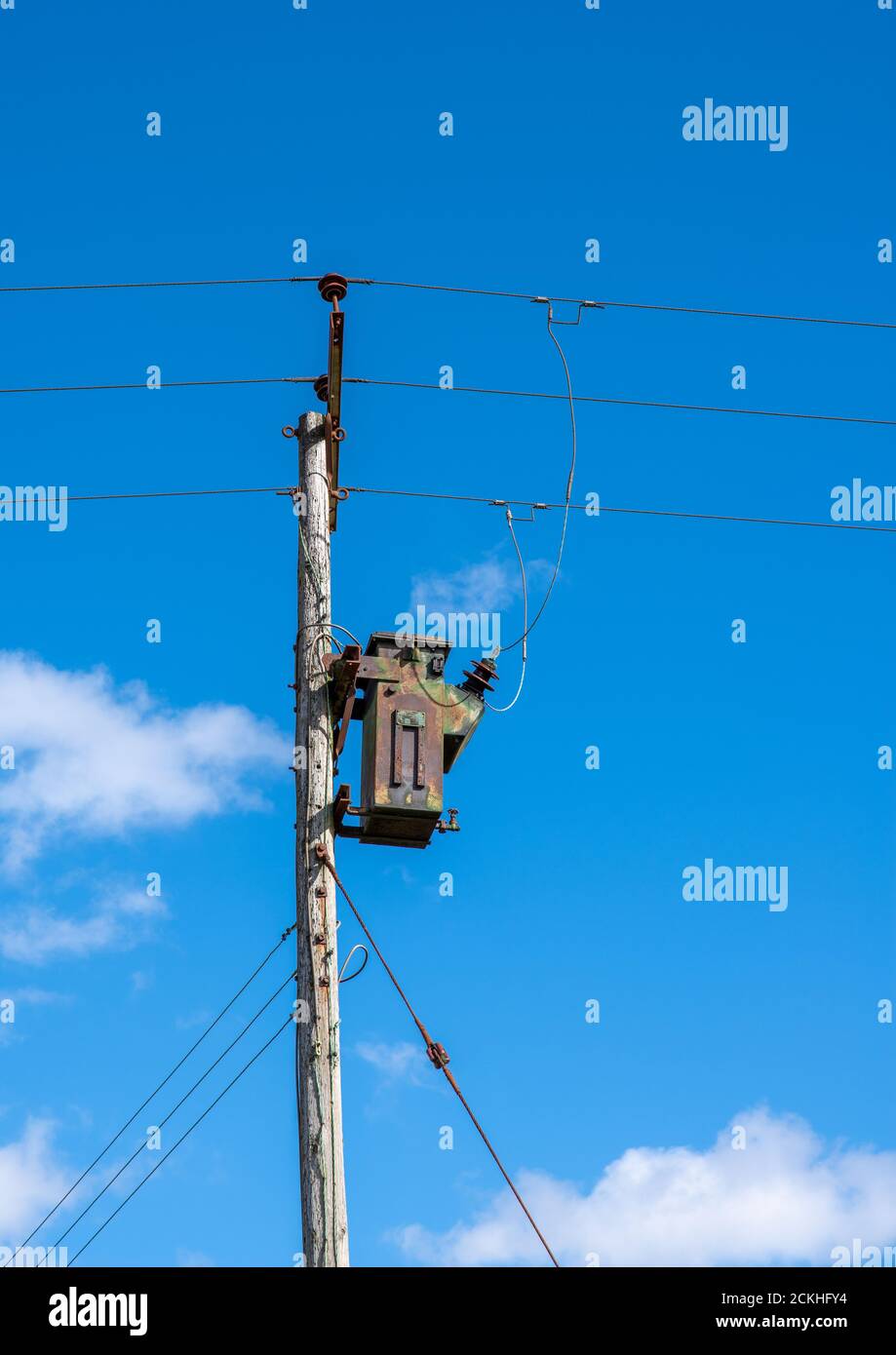 Telegraph Pylon im Pole-Stil mit einem elektrischen Transformator mit einem wolkigen Himmel Hintergrund Stockfoto