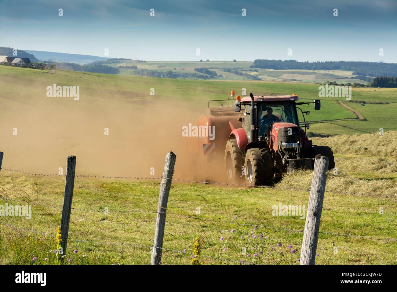 Traktor arbeitet während der Ernte auf der Cezallier-Hochebene im regionalen Naturpark der Vulkane der Auvergne, Puy de Dome, Auvergne-Rhone-Alpes, Frankreich Stockfoto