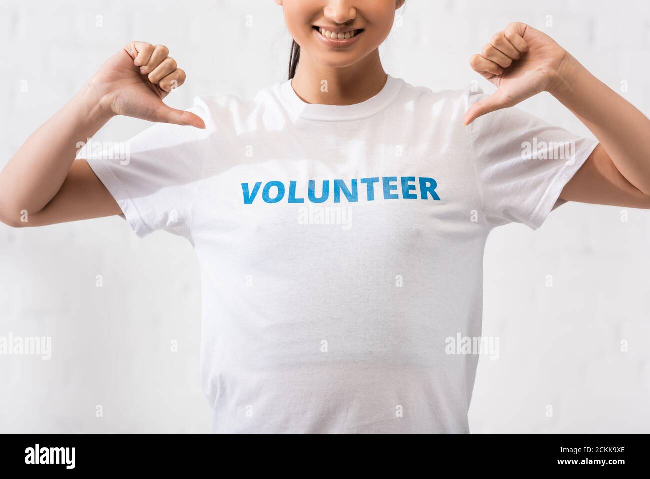 Verkürzte Ansicht des Freiwilligen zeigt auf T-Shirt mit Schriftzug Stockfoto