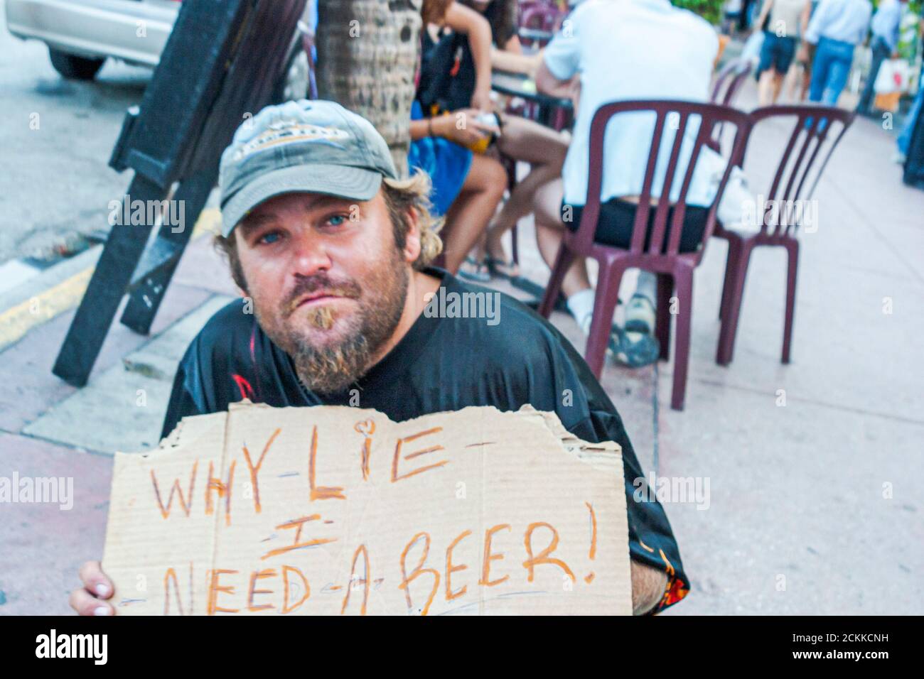 Miami Beach Florida, South Beach, Ocean Drive vagrant obdachlos Bettler bum Vagabund, hält hält Zeichen Warum Lüge ich brauche ein Bier, Stockfoto