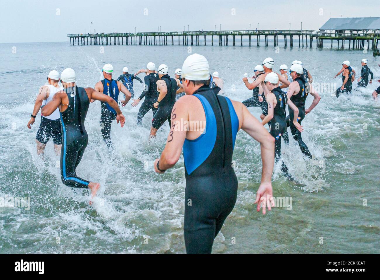 Hampton Virginia,Tidewater Area,Buckroe Beach,Tri American Triathlon jährliche Veranstaltung,Schwimmer Männer männliche Teilnehmer beginnen ein Wettlauf ins Wasser Stockfoto