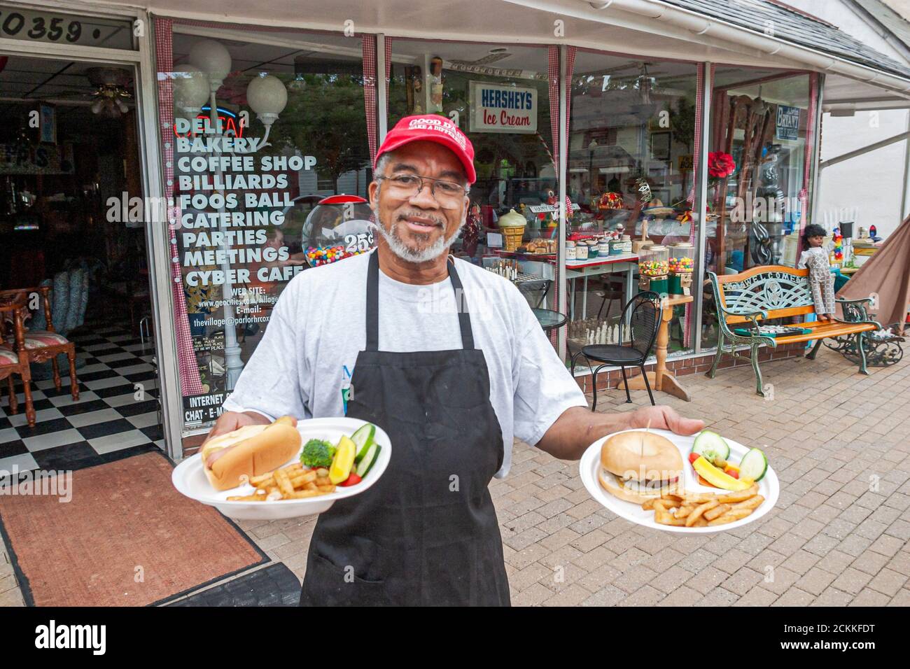 Newport News Virginia, Historic Hilton Village Parlor Restaurant Black man männlicher Kellner, der eine Bestellung zum Mittagessen serviert, Hot Dog Pommes Frites, Arbeiter Stockfoto