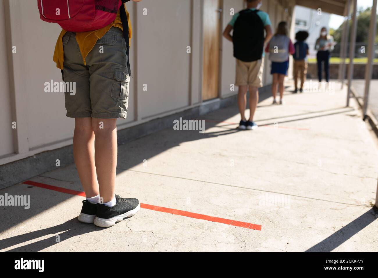 Rückansicht einer Gruppe von Kindern, die soziale Distanz aufrecht erhalten Schule Stockfoto