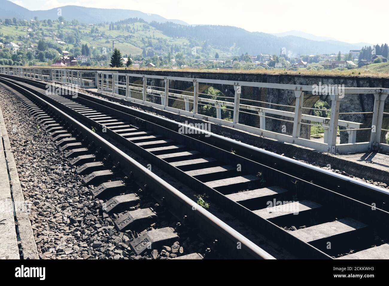 Bahnschienen in der Landschaft. Eisenbahnschienen bei Sonnenuntergang. Lokales Reisekonzept Stockfoto