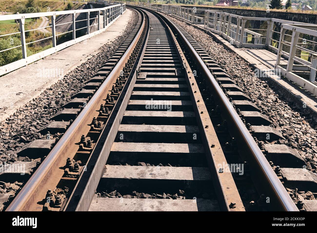 Bahnschienen in der Landschaft. Eisenbahnschienen bei Sonnenuntergang. Lokales Reisekonzept Stockfoto