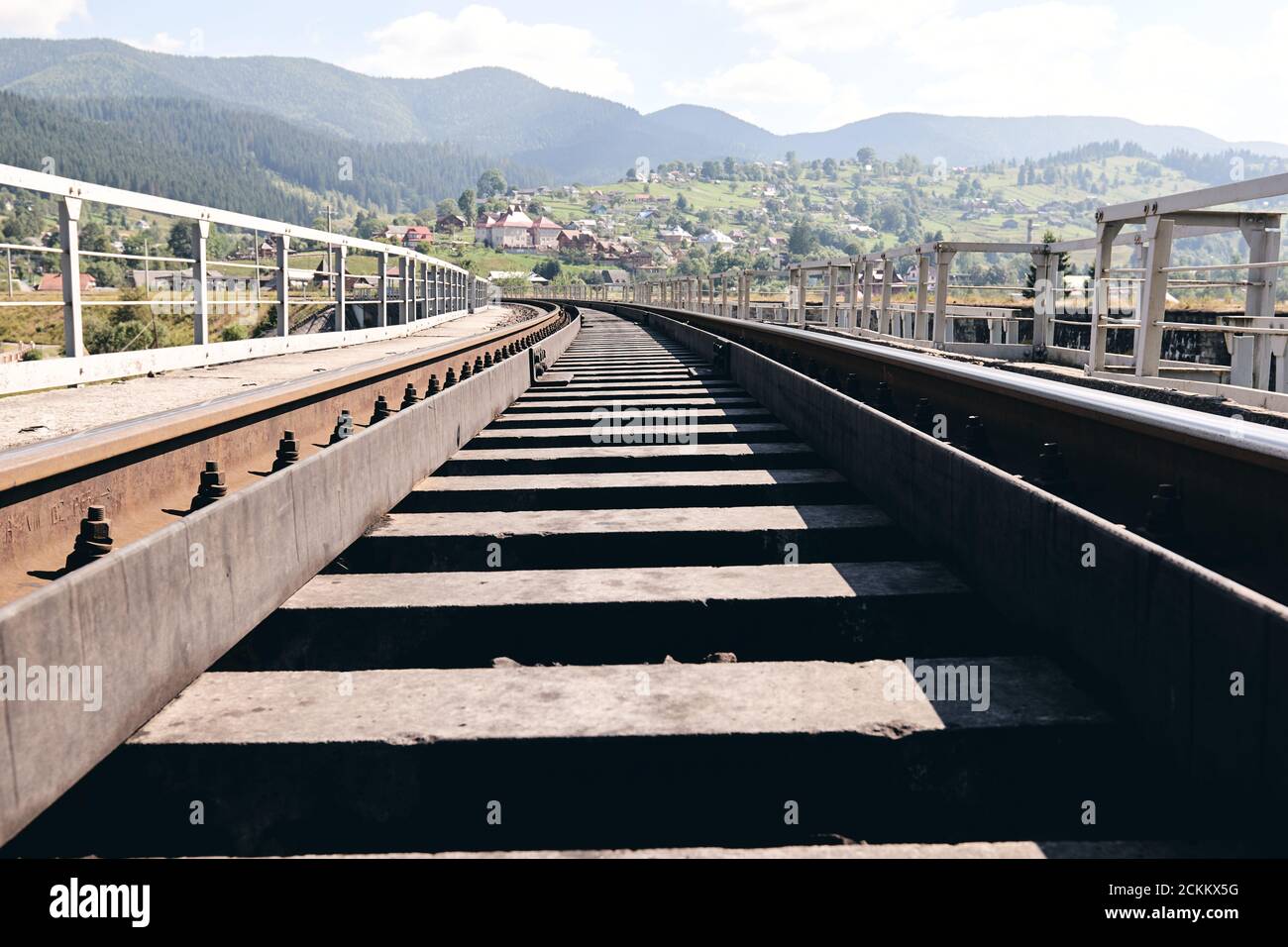 Bahnschienen in der Landschaft. Eisenbahnschienen bei Sonnenuntergang. Lokales Reisekonzept Stockfoto