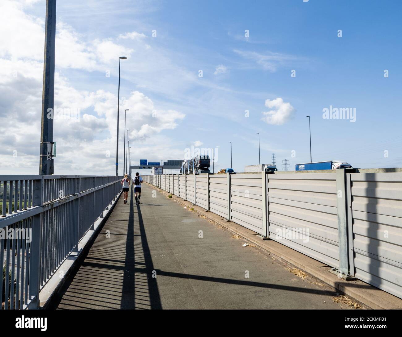 Jogger auf dem Fuß- und Radweg entlang der M5 Als es die Meile lange Avonmouth Bridge über die überquert River Avon in Somerset UK Stockfoto