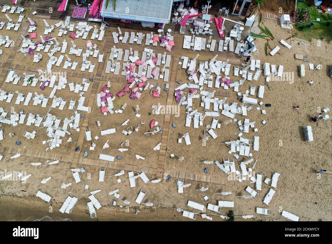 Nea Plagia, Chalkidiki, Griechenland - 10. Juli 2019: Luftaufnahme von beschädigten Sonnenschirmen und Sonnenliegen am Strand in Nea Plagia nach einem Sturm und Tornados Stockfoto