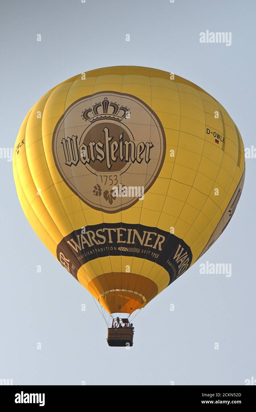 Schleswig, Deutschland. September 2020. 14.09.2020, Schleswig, ein gelber Heißluftballon mit Werbung der Warsteiner Brauerei auf der Ballonhülle, reitet am Abendhimmel bei schönem Spätsommerwetter über Schleswig. Quelle: dpa/Alamy Live News Stockfoto