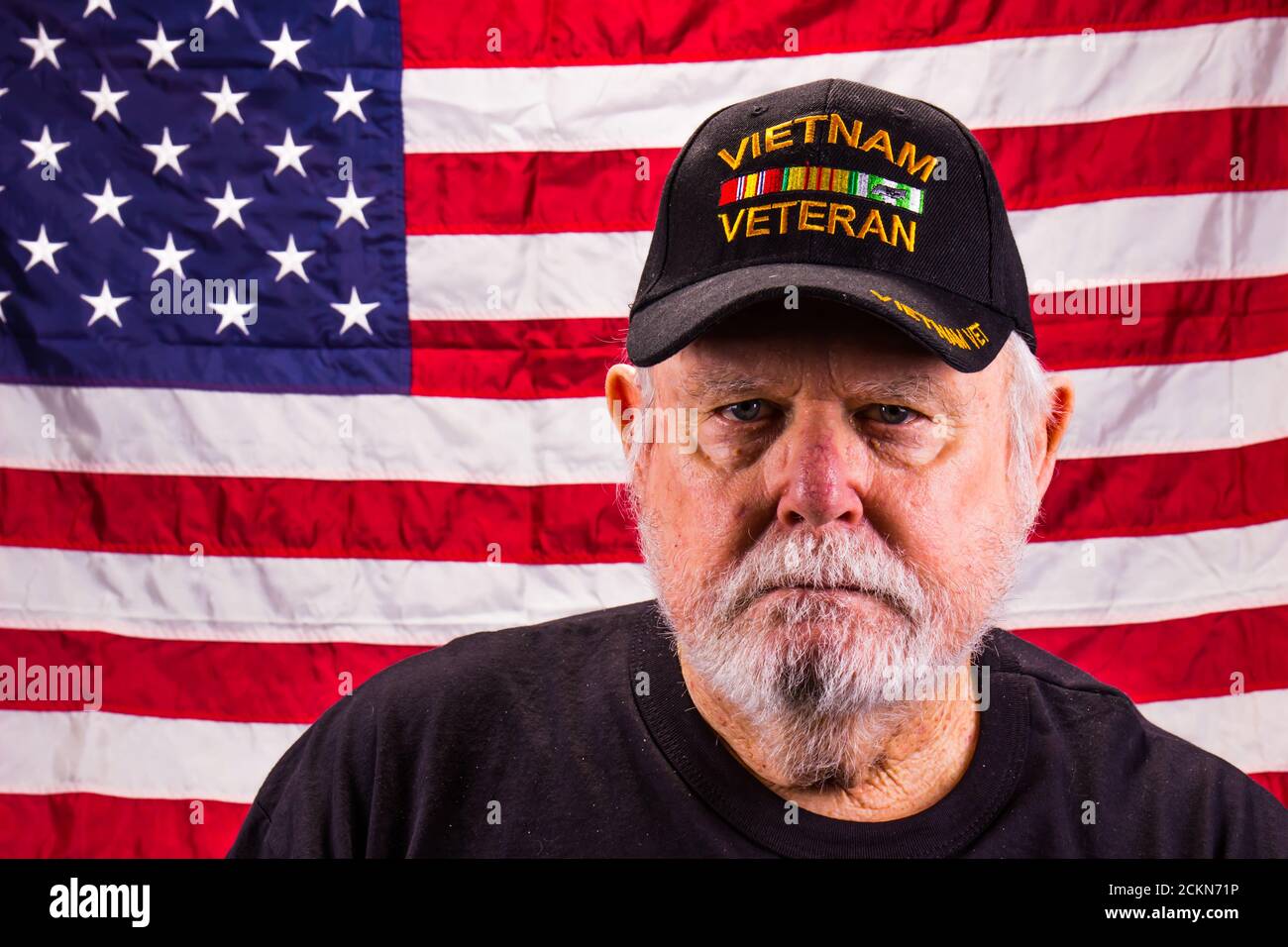 Vietnam Veteran Blick Direkt In Die Kamera Mit Amerikanischen Flagge Hintergrund Stockfoto