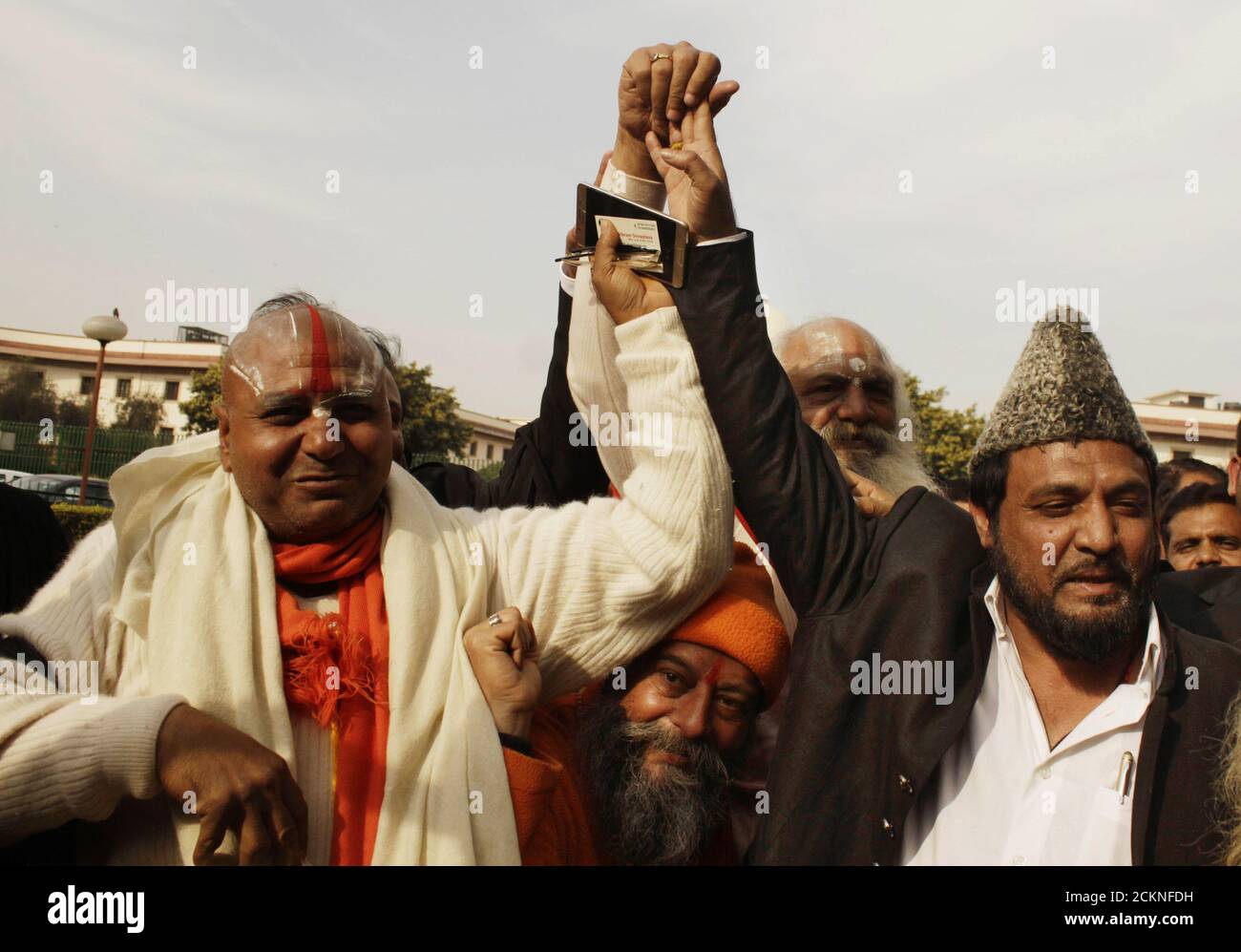 Vertreter von Oppositionsparteien, muslime aus Babri Masjid und hindus aus dem RAM Janmabhumi Moment Streit halten sich gegenseitig die Hand als Geste Stockfoto