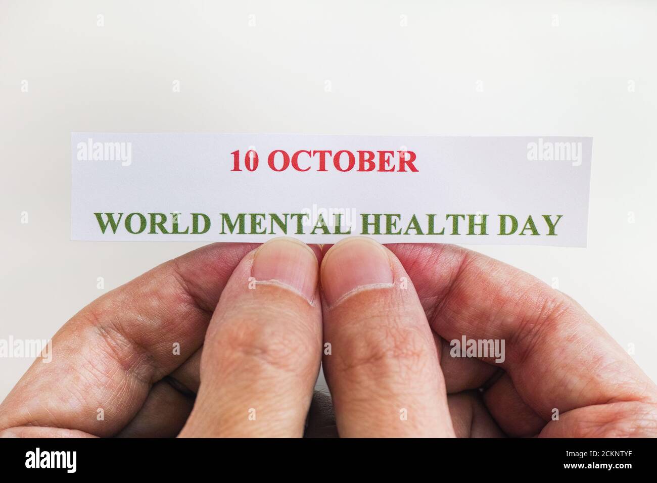 Person, die ein Stück Papier mit den Worten Welttag der psychischen Gesundheit hält (10. Oktober). Nahaufnahme. Stockfoto