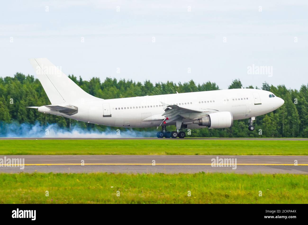 Flugzeug landet auf der Landebahn am Flughafen mit Rauch aus dem Fahrgestell. Harte Landung Stockfoto