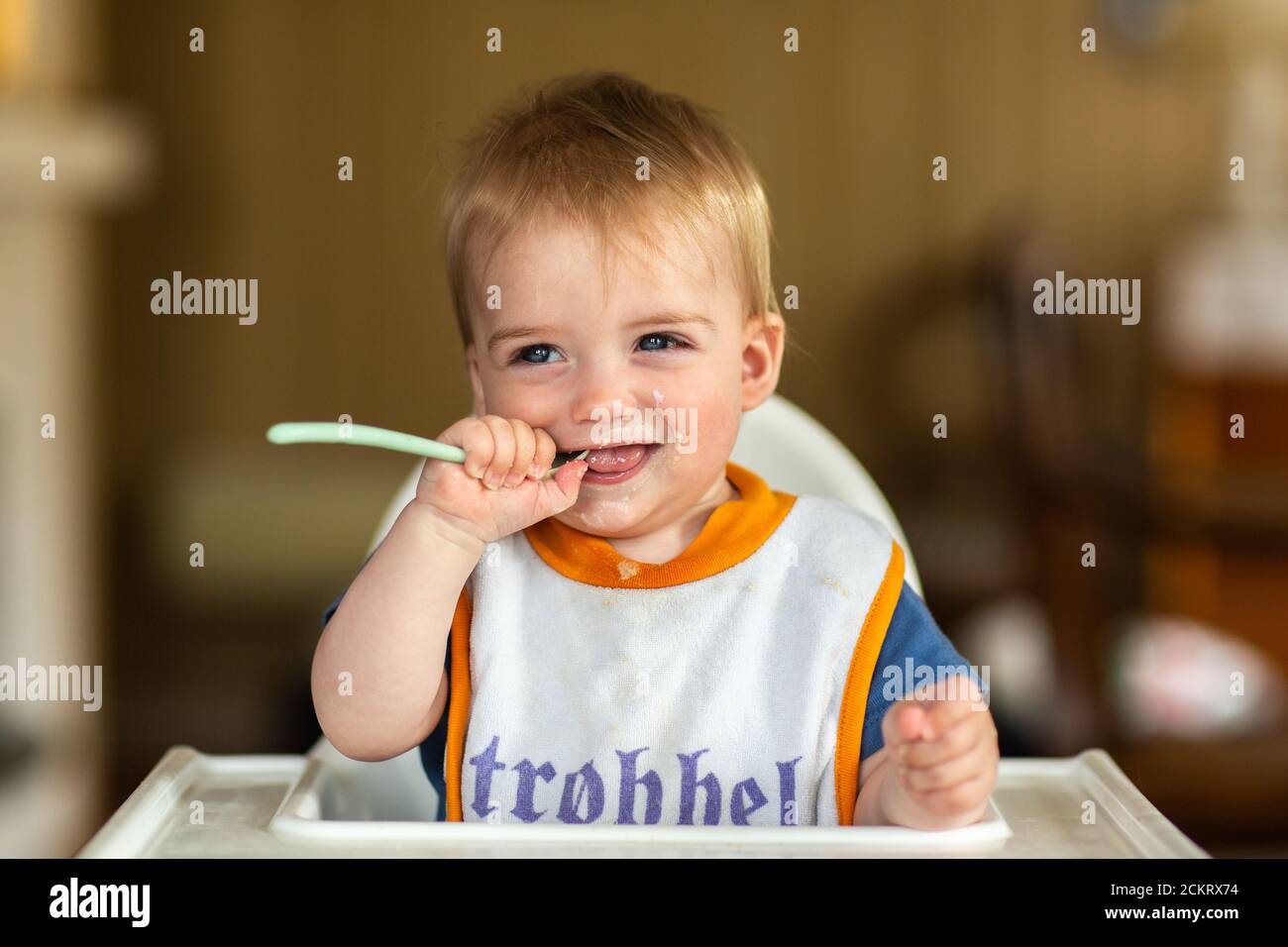 8-12 Monate alter Junge in einem Hochstuhl bei den Mahlzeiten Stockfoto