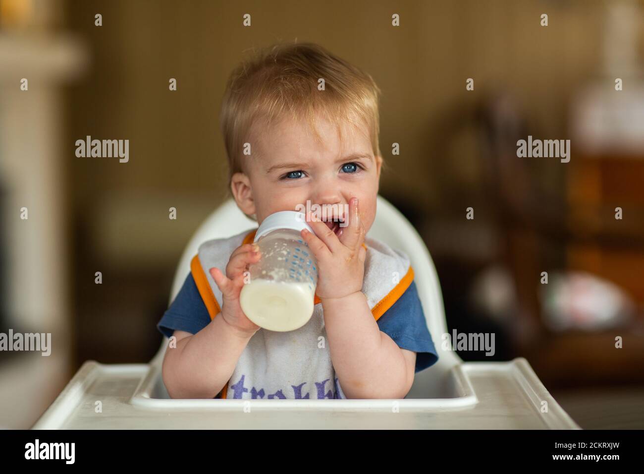 8-12 Monate alter Junge in einem Hochstuhl bei den Mahlzeiten Stockfoto