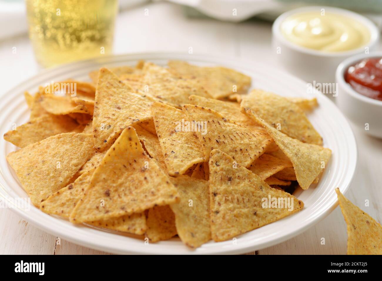 Platte mit Nacho-Mais-Chips und Dips auf Holz Hintergrund Stockfoto