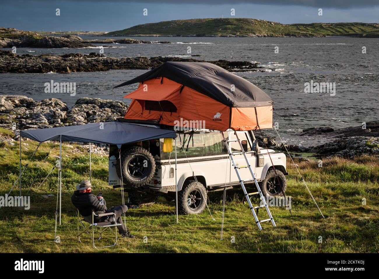 Clifden, Irland - 25. Juli 2020; EIN Mann, der an der Westküste Irlands in einem Land Rover mit Dachzelt zeltet Stockfoto
