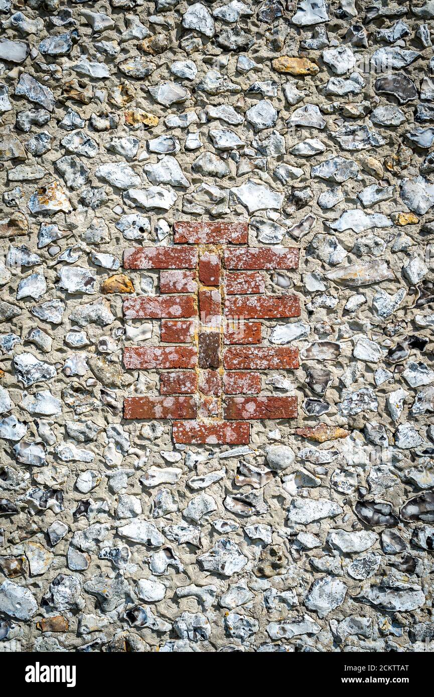 Nahaufnahme eines Mauerwerks aus Ziegel und Feuerstein. Traditionelle Bauweisen. Stockfoto