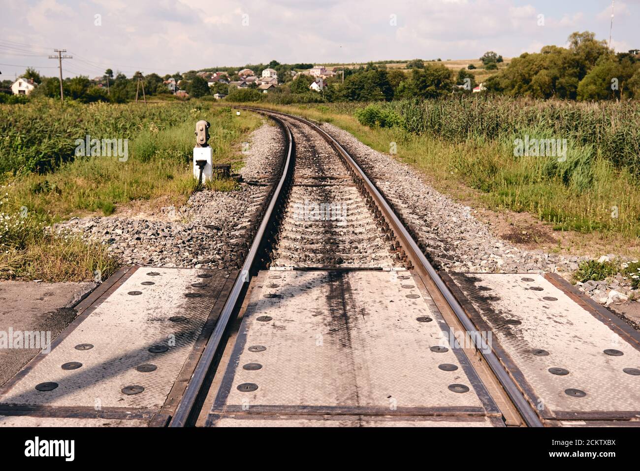 Bahnschienen in der Landschaft. Eisenbahnschienen bei Sonnenuntergang. Lokales Reisekonzept Stockfoto