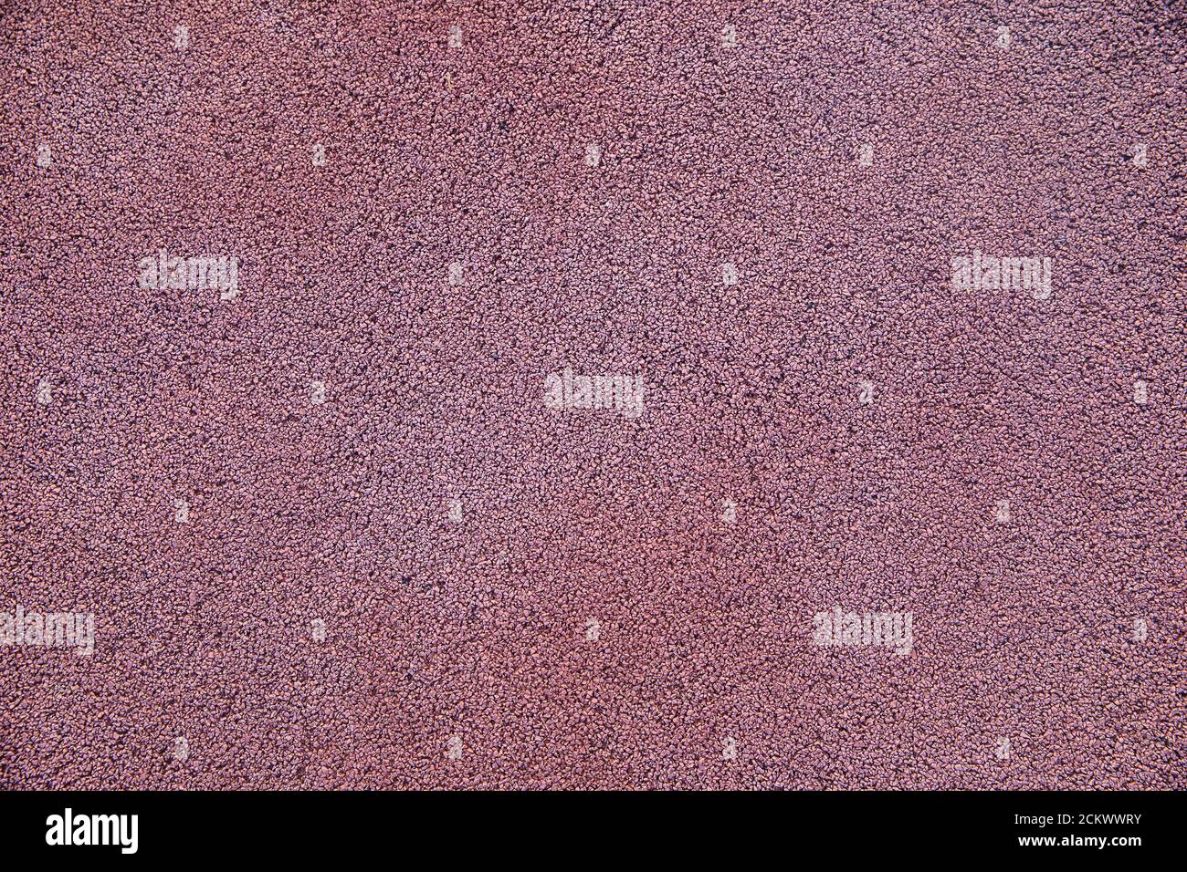 Die Textur des Pfades ist mit kleinen roten bedeckt Steine Stockfoto