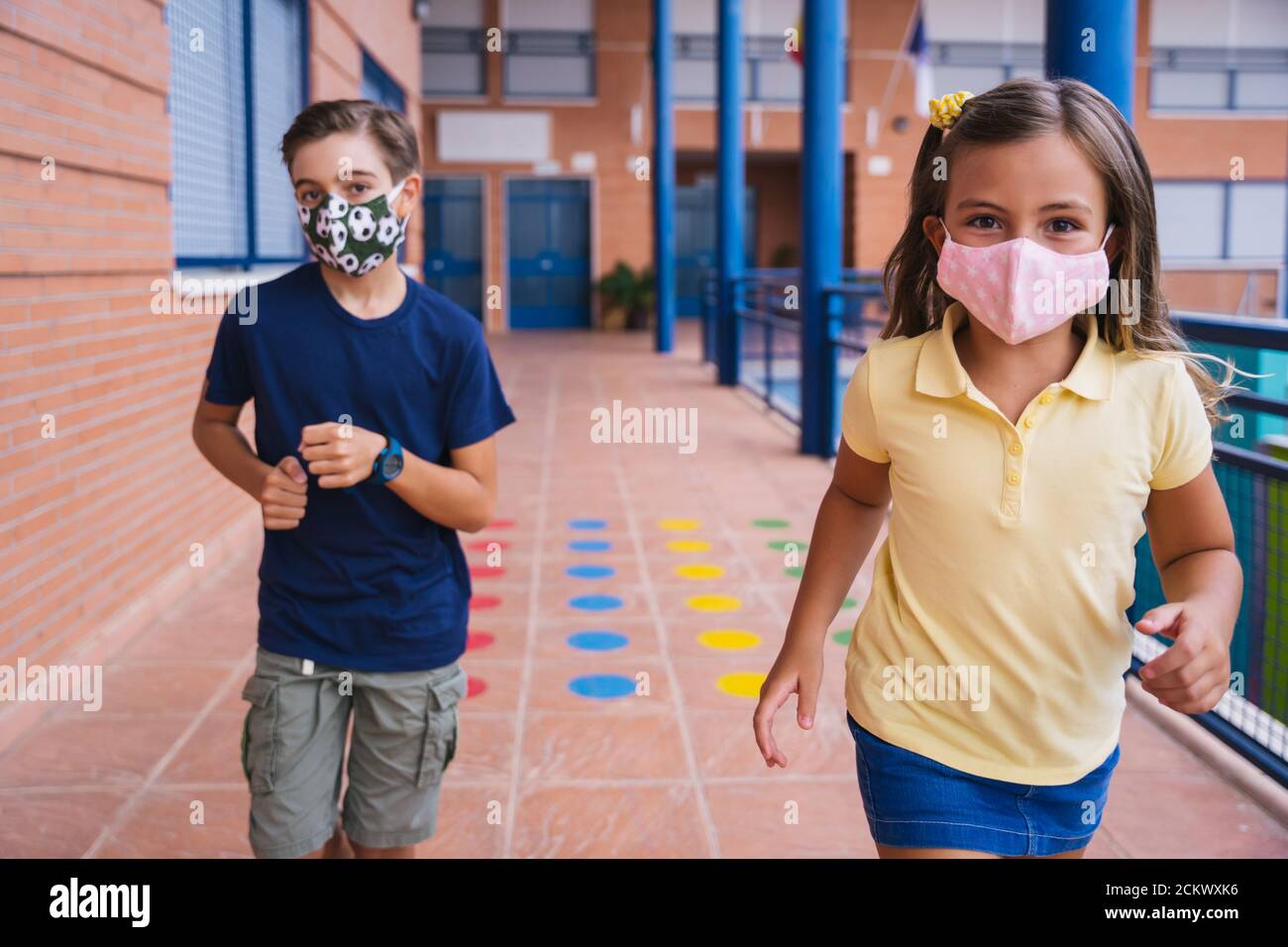 Zurück zur Schule. Kinder laufen auf dem Schulhof mit Gesichtsmaske Stockfoto