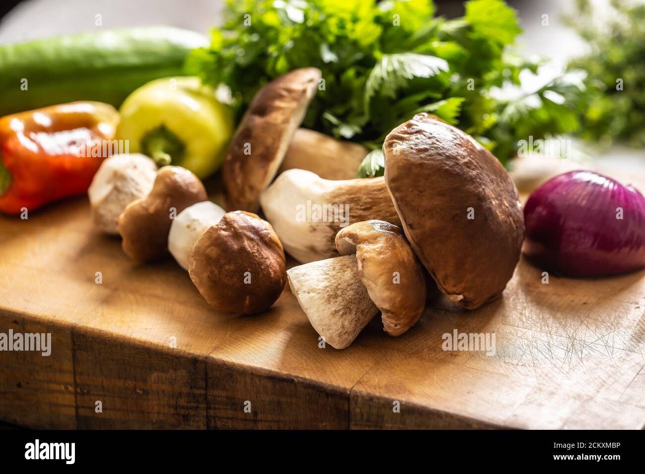 Wildpilze, Zwiebeln, Paprika und Kräuter auf einem Holztisch Stockfoto